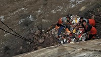 Dinding kali yang cukup terjal dan tinggi membuat petugas menggunakan alat berat untuk mengangkut sampah yang telah dibersihkan oleh petugas dari kali.