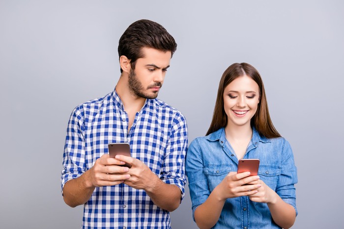 Ilustrasi pasangan memegang ponsel. Foto: Dok. iStock Ilustrasi pasangan memegang ponsel. Foto: Dok. iStock