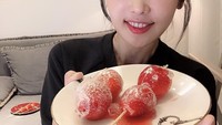 Meskipun pernah bekerja sebagai dokter gigi. Lee Su Jin juga hobi menikmati makanan manis. Kali ini buah strawberry dengan lapisan gula yang renyah jadi camilannya. Foto: Instagram@sjeuro