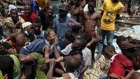 Petugas penyelamat bersama warga mengevakuasi salah satu anak yang terjebak di dalam reruntuhan gedung sekolah yang roboh di kawasan Lagos, Nigeria. Afolabi Satunde/Reuters.
