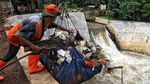 Aksi Petugas UPK Bersihkan Sampah Di Kali Baru Timur