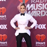 Halsey tampil maskulin dengan kemeja putih dan dasi kupu-kupu. Penampilannya tetap stylish berkat potong asimetris pada bajunya dan paduan bersama high heels. Foto: Getty Images