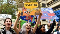 Dalam aksinya mereka membawa sejumlah atribut seperti poster. AAP Image/Mick Tsikas/via REUTERS.