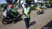 Masyarakat sekitar menjaga perlintasan kereta tersebut secara bergantian.