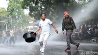Warga yang terprovokasi melemparkan sejumlah benda ke barisan polisi.