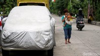 Kurangnya lahan parkir membuat warga memilih memarkirkan mobil mereka di bahu jalan.