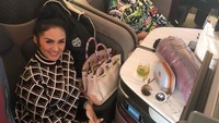 Wanita kelahiran Batu, Malang ini sering bepergian ke luar negeri bersama sang suami. Perjalanan di pesawat makin lengkap dengan suguhan minuman. Foto: Instagram krisdayantilemos