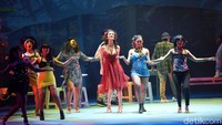 Dari atas panggung teater, ia menggunakan gaun selutut terbuka berwarna merah menyala. Foto: (Noel/detikhot)