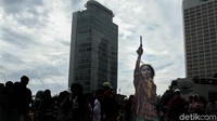 Warga yang berolahraga berhenti sejenak untuk menyaksikan teatrikal.