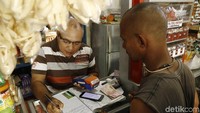 Kornelis Dagut  melayani nasabah langsung di toko kelontongnya di Labuan Bajo. Selain membantu warga untuk transfer dan tarik tunai,  agen BRILink juga  dapat keuntungan.