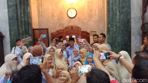 Sandiaga berfoto dengan jemaah di masjid.