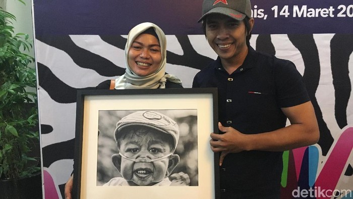 Winda dan Sanudin, berpose bersama foto Raka, pengidap Cutis Laxa Syndrome. Foto: Frieda Isyana Putri/detikHealth Winda dan Sanudin, berpose bersama foto Raka, pengidap Cutis Laxa Syndrome. Foto: Frieda Isyana Putri/detikHealth