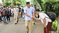 Sandiaga juga menyalami jemaah di masjid dan meladeni permintaan foto bersama. Para jemaah tampak memakai kemeja kerah berwarna biru yang merupakan outfit khas Sandiaga selama kampanye.