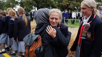 Para siswa dari sebuah sekolah Kristen di Selandia Baru mendatangi keluarga korban penambakan yang tengah menunggu kabar nasib keluarga mereka yang terluka. REUTERS/Jorge Silva.