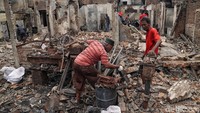 Warga nampak kembali ke rumah mereka yang telah hangus terbakar untuk mengumpulkan barang-barang yang masih bisa diselamatkan.