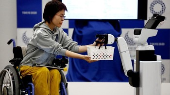 Aksi robot HSR mengantarkan keranjang ke seorang perempuan di kursi roda. (Foto: REUTERS/Kim Kyung-hoon)