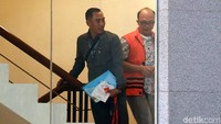 Tohonan mengenakan rompi oranye khas KPK dengan tangan diborgol menuju ruang pemeriksaan.