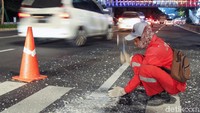 Terkendala mesin yang rusak, petugas terpaksa mengkapus garis secara manual.