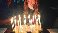 Kue cokelat bertopping biskuit yang dikelilingi lilin putih panjang jadi kue ulang tahun Jennifer ke-21. Sosok Nassar berada tepat di samping Jennifer. Foto: Instagram jennfierkgates