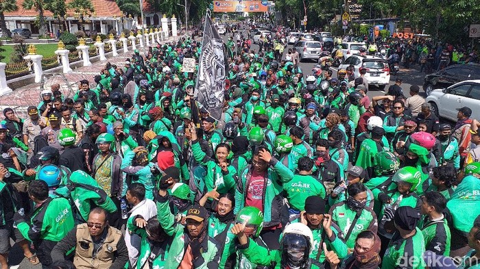 Aksi unjuk rasa ribuan ojol di Surabaya diwarnai dengan pembakaran keranda sebagai bentuk kekesalan. Ini foto-fotonya.