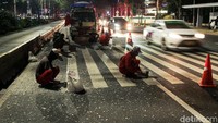 Kini petugas menghapus garis zebra cross yang membentang di Jalan Sudirman tersebut.