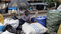 Salah seorang pemulung sedang membersihkan sampah plastik yang telah dikumpulkannya sebelum dijual kembali ke pengepul.
