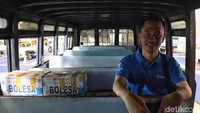 Salah bus dengan deretan kursi penumpang memanjang.