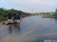Jalan di Desa Gedong Karya, Kecamatan Kumpe, Muaro Jambi, Jambi tergenang. Akibatnya akses jalan penghubung antar desa terputus. 
