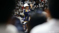 Jokowi berpidato dengan memakai helm kerja berwarna putih.