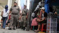 Sejumlah petugas Satpol PP melakukan patroli di trotoar kawasan Tanah Abang, Jakarta, Kamis (21/3/2019).