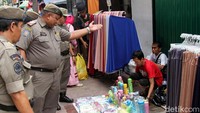 Para pedagang yang ketahuan nakal bergegas menggeser dagangannya.