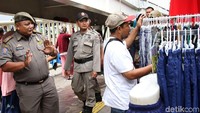 Petugas Satpol PP memberikan teguran dan arahan agar para PKL tidak berdagang di atas trotoar.