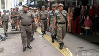 Sejumlah petugas Satpol PP menyusuri trotoar di kawasan Tanah Abang untuk memberikan peringatan kepada para PKL yang masih membandel berdagang di atas trotoar.