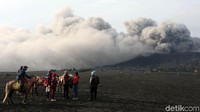 Wisatawan memandangi asap yang membubung dari kawah Gunung Bromo. Abu vulkanik diketahui masih disemburkan dari kawah Gunung Bromo. Namun, tinggi semburan abu itu telah menurun menjadi 300-900 meter saja.