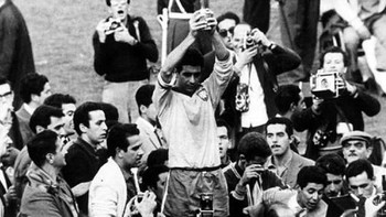 Pada perayaan kemenangan Piala Dunia 1962 yang disabet timnas Brasil, ada yang cukup aneh. Tampak di posisi bawah depan, kelihatannya seseorang memakai ponsel lipat untuk mengabadikan momen tersebut. Apakah dia penjelajah waktu? Foto: istimewa