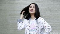 Astrid tampil dengan kemeja putih bermotif dan celana hijau panjang. Pool/Palevi S/detikFoto.
