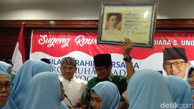 Sandiaga Uno menunjukkan isi bingkisan dari keluarga KH Ahmad Dahlan. 