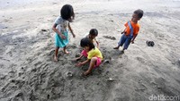 Anak-anak tengah bermain pasir di Pantai Bohai.