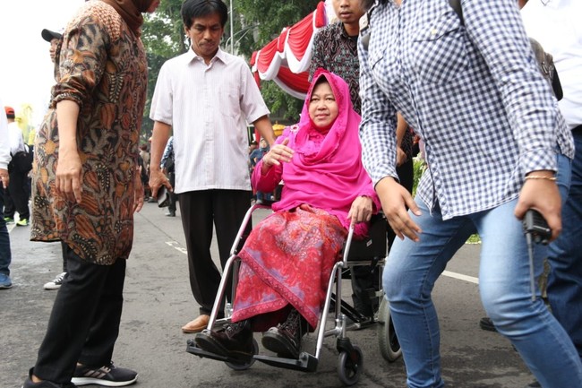 Pernah pula ia memakai kebaya berwarna pink terang yang dipadu dengan boots coklat tua bermerek Dr. Martens. Ini yang mesti didelok sepatu bootsku. Bu Risma kebayaan kok pake boots, kata Tri Rismaharini diiringi dengan gelak tawa ratusan masyarakat Surabaya yang hadir di sebuah acara di sekitar Tugu Pahlawan Surabaya, Minggu (24/3/2019). (Foto: Dok. Hilda Meilisa Rinanda/Detikcom)