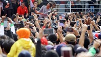 Dari atas panggung, Jokowi juga melakukan swafoto dengan warga yang ada di bawah.