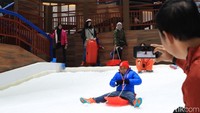Seorang ayah memotret anaknya di seluncuran salju. Trans Snow World cocok banget untuk liburan keluarga (Randy/detikcom)