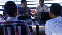Petugas dengan ramah melayani warga yang sedang mengurus surat dan pajak kendaraan.