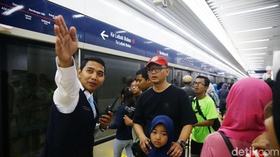 Potret Petugas Bantu Warga yang Antusias Naik MRT
