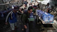 Para penjual air bersih ini selalu tampil kompak. Mereka akan membantu mendorong gerobak rekannya yang penuh dengan muatan air bersih.
