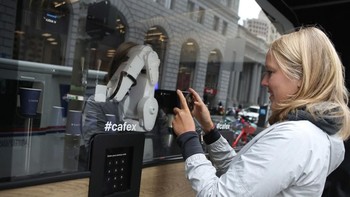 Tak sedikit yang merasa tergelitik untuk mengabadikan aksi si robot barista dengan ponselnya. (Foto: Justin Sullivan/Getty Images)
