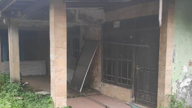Jendela dan pintu tampak rusak.