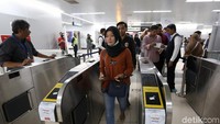 Satu per satu warga melintasi palang pintu otomatis yang mengarahkan warga ke peron MRT.