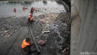 Petugas mengumpulkan sampah plastik yang hanyut dan menyebar di Kali Sungai Cagak. Di bagian lain, ada pula petugas yang bertugas membersihkan endapan lumpur di kali tersebut.