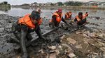 Aksi Petugas UPK Badan Air Mandi Lumpur Bersihkan Sampah