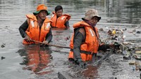 Kondisi sampah yang menyebar dan hanyut di kali itu membuat petugas mau tak mau menceburkan diri untuk mengumpulkan sampah.